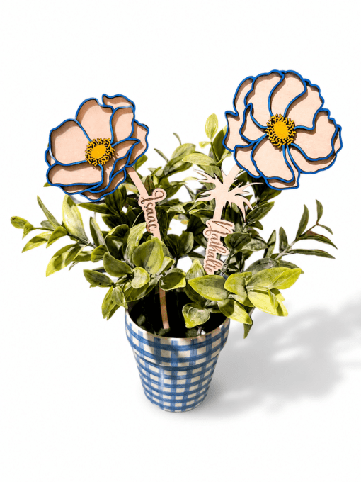 Composition de deux fleurs en bois personnalisées avec prénoms dans une plante artificielle
