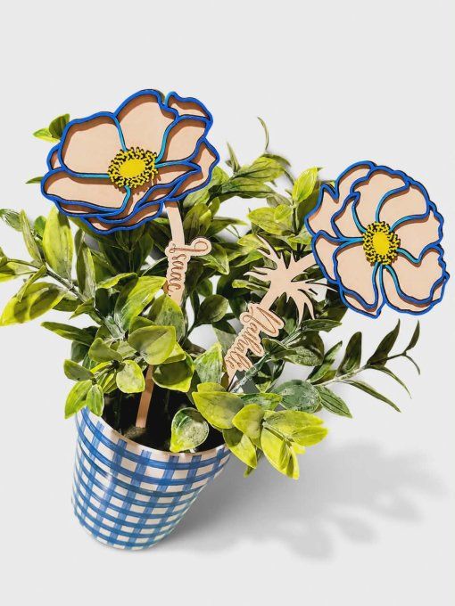 Deux fleurs en bois personnalisées avec les prénoms Isaac et Nathalie